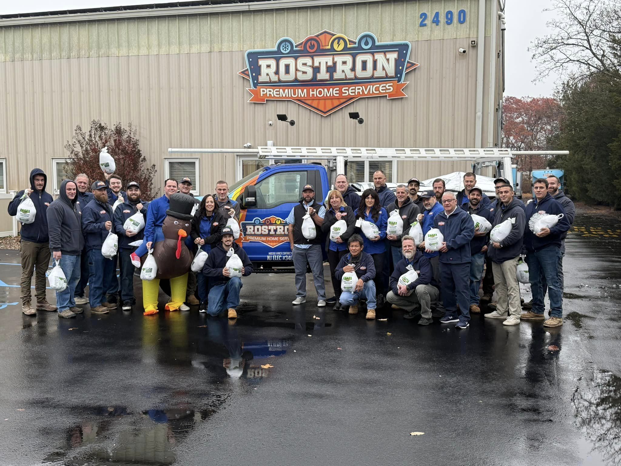 The team at Rostron Premium Home Services posing with the turkeys they donated to fulfill food bank.